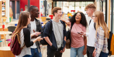 Student Group Socializing In Communal Area Of Busy College
