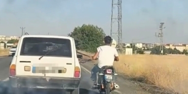 otoyolda-tehlikeli-yolculuk-motosiklet-otomobil-kemerine-tutunarak-ilerledi-b1VUeURA.jpg